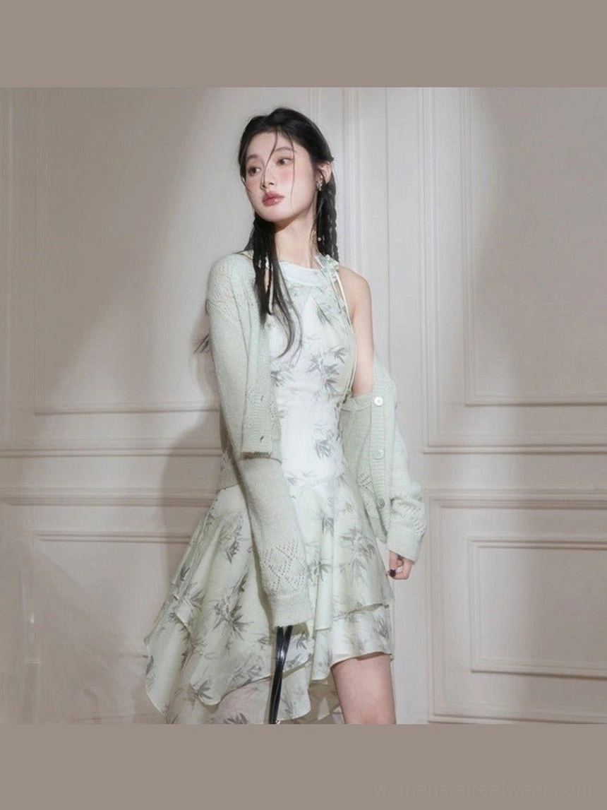 Full length model wearing a green ink bamboo print halter midi dress with asymmetric ruffled hem and oversized grey blazer