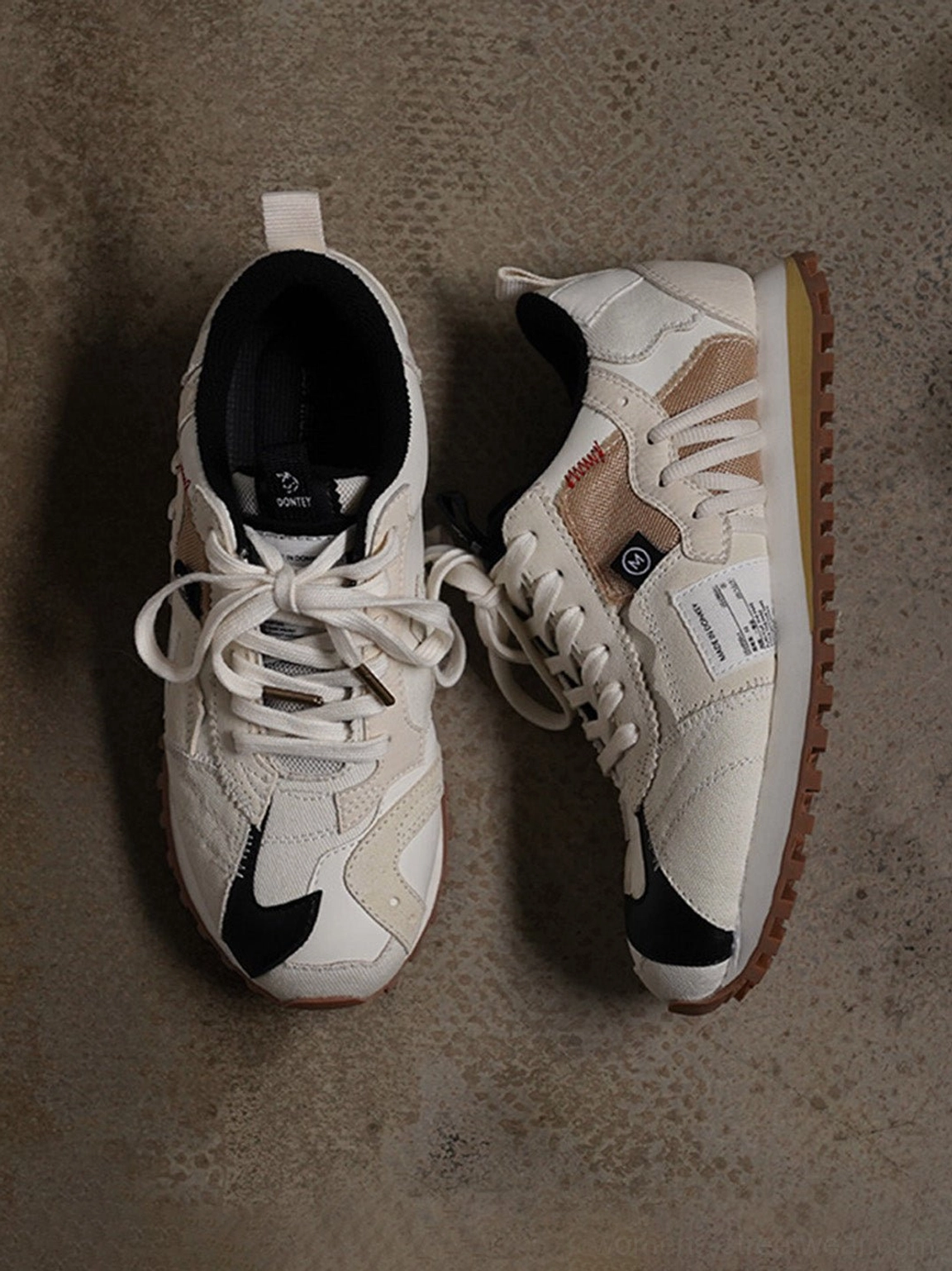 Ivory and black retro runner sneakers with layered microfiber synthetic leather upper and textured rubber waffle sole
