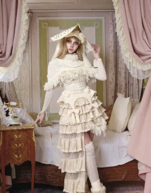 Ivory high collar cable knit fringe capelet shown in a full winter dollcore outfit with layered asymmetric skirt