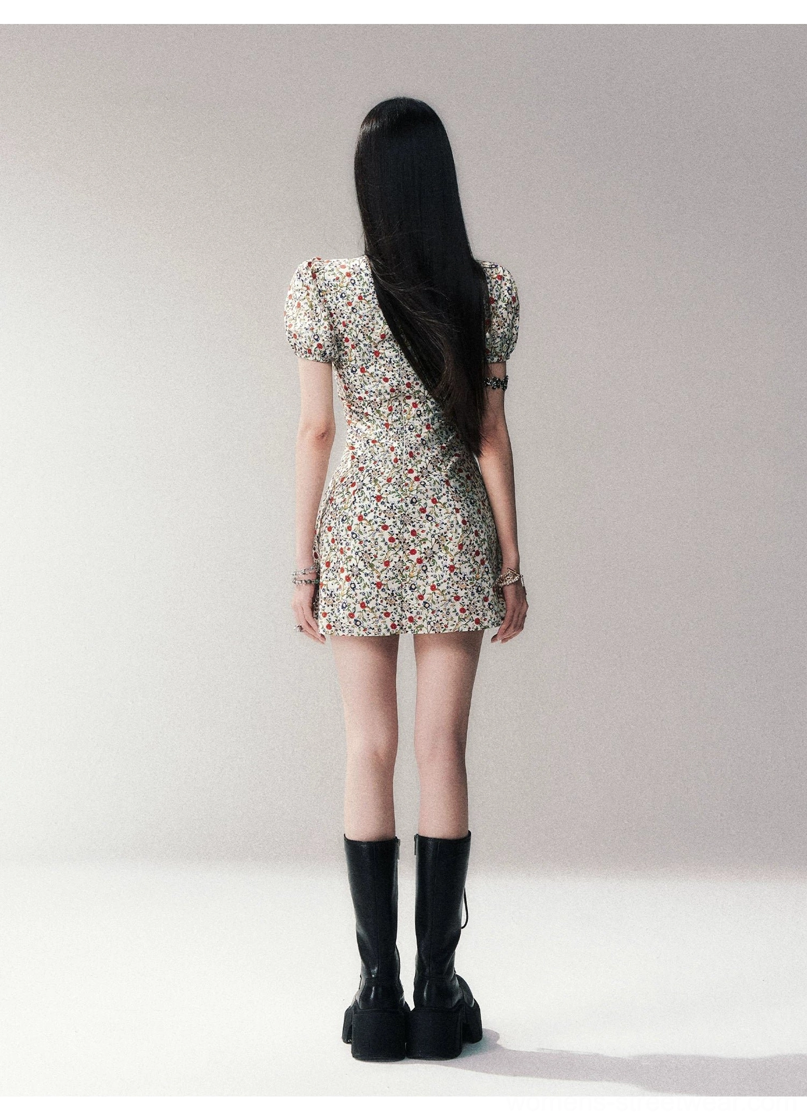 Back view of ivory ditsy floral puff sleeve A-line mini dress styled with black platform boots
