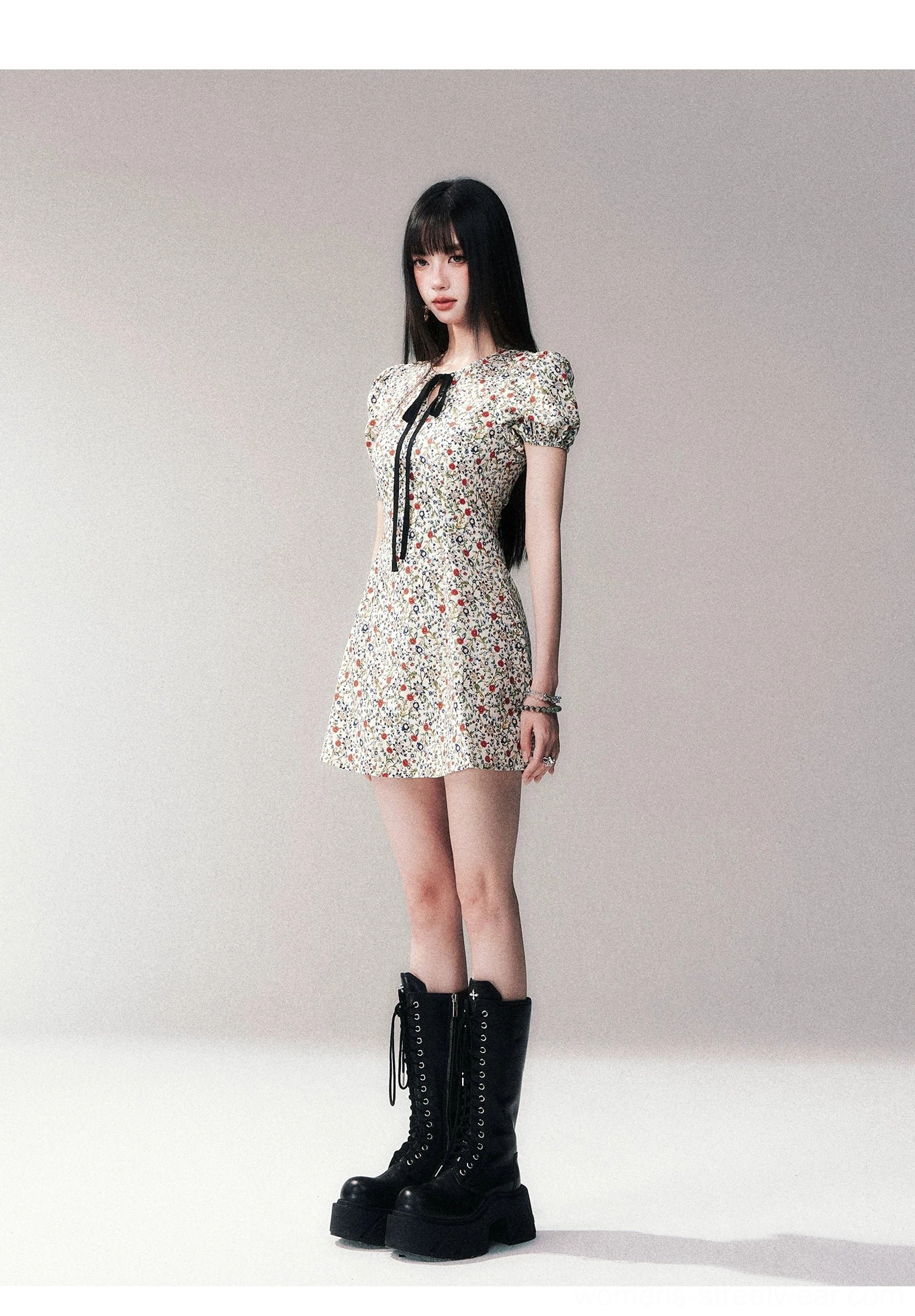 Full studio view of ivory ditsy floral bow-tie puff sleeve A-line mini dress with black platform boots