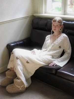 Ivory embroidered ruffle trim knit cardigan and skirt set styled in a vintage living room with textured crochet details and V-neck cardigan