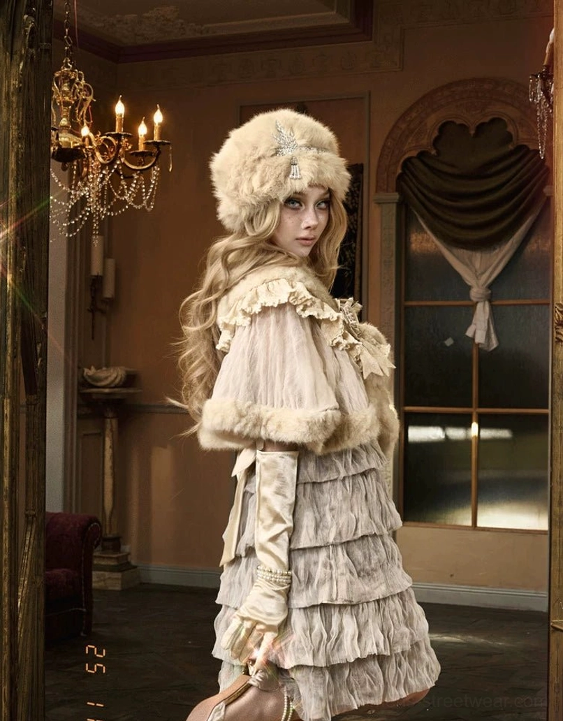 Side profile of romantic ivory faux fur capelet styling with sheer ruffles long gloves and matching fur hat