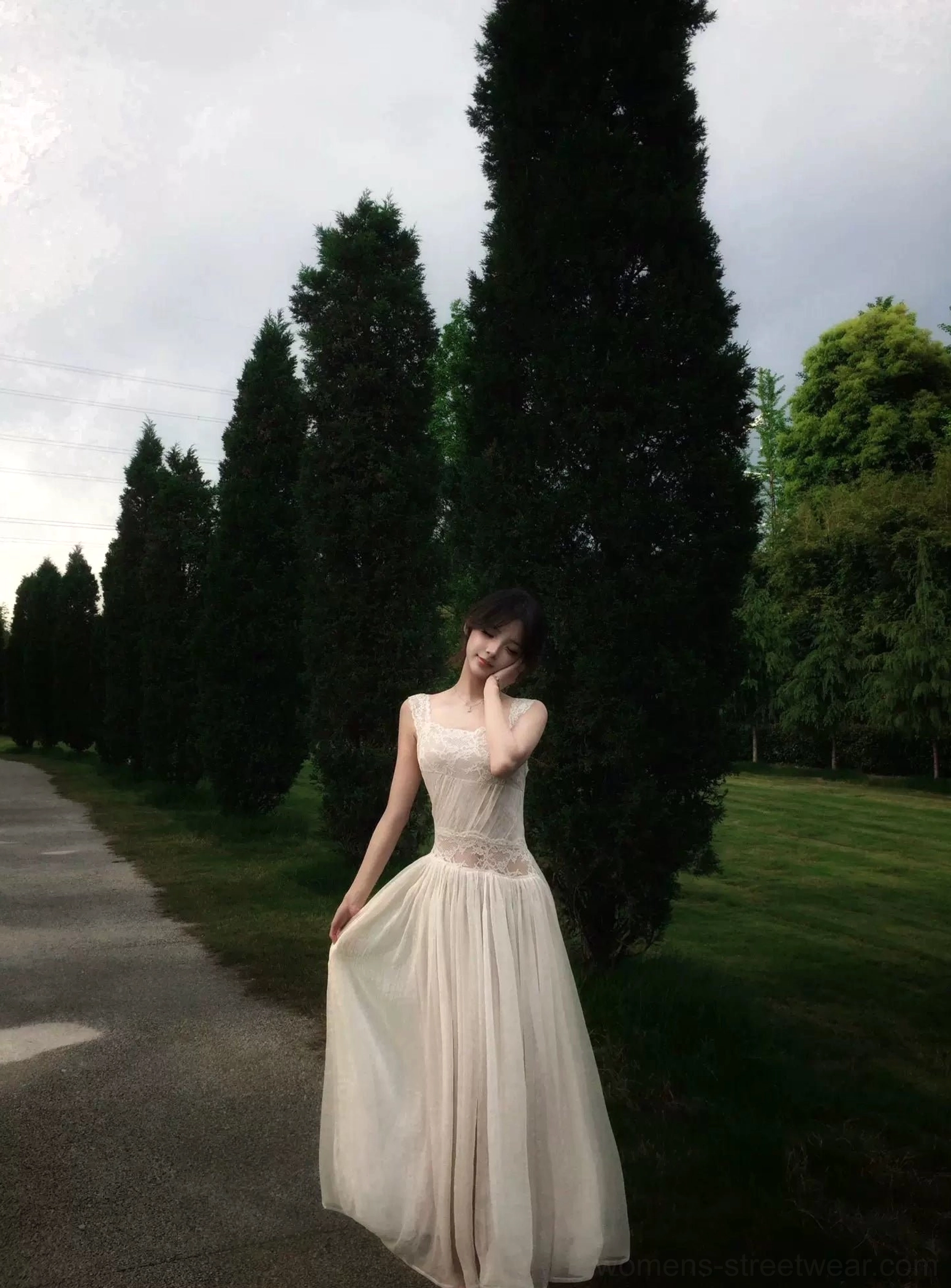 Front three-quarter view of an ivory lace waist maxi dress with delicate spaghetti straps, lace bodice panel, high waist, and flowing full-length skirt