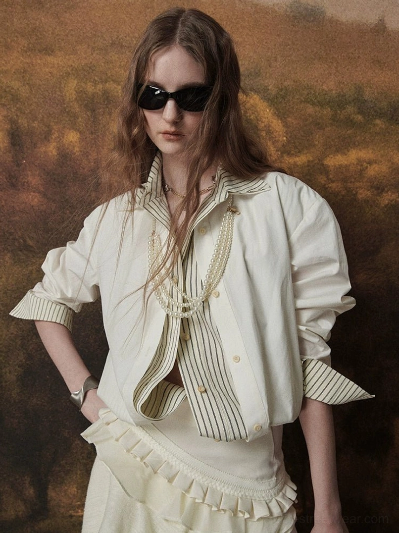 Close-up view of a woman wearing an ivory layered striped collar shirt with matching striped cuffs, pearl necklaces, and sunglasses in an East Asian fashion look