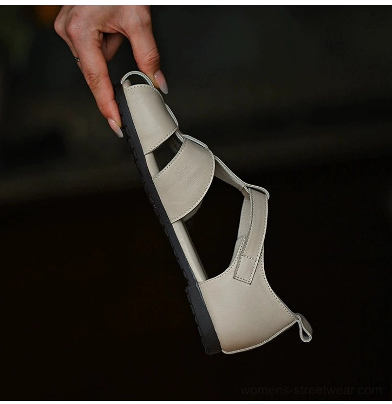 Ivory leather cutout sandals shown from below with dual cross straps, flat outsole, and practical heel pull tab