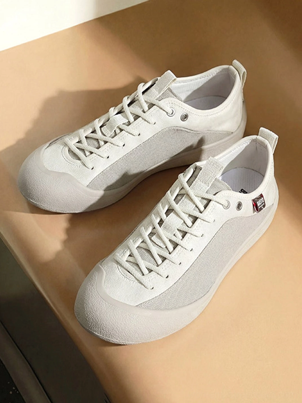Top right view of white gray ivory mesh-panel canvas low-top sneakers showing lace-up upper details