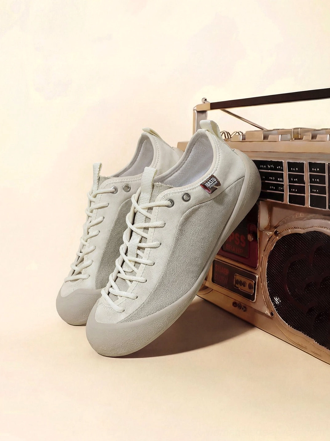 Angled side view of ivory mesh-panel canvas low-top sneakers in white gray with slim rubber sole