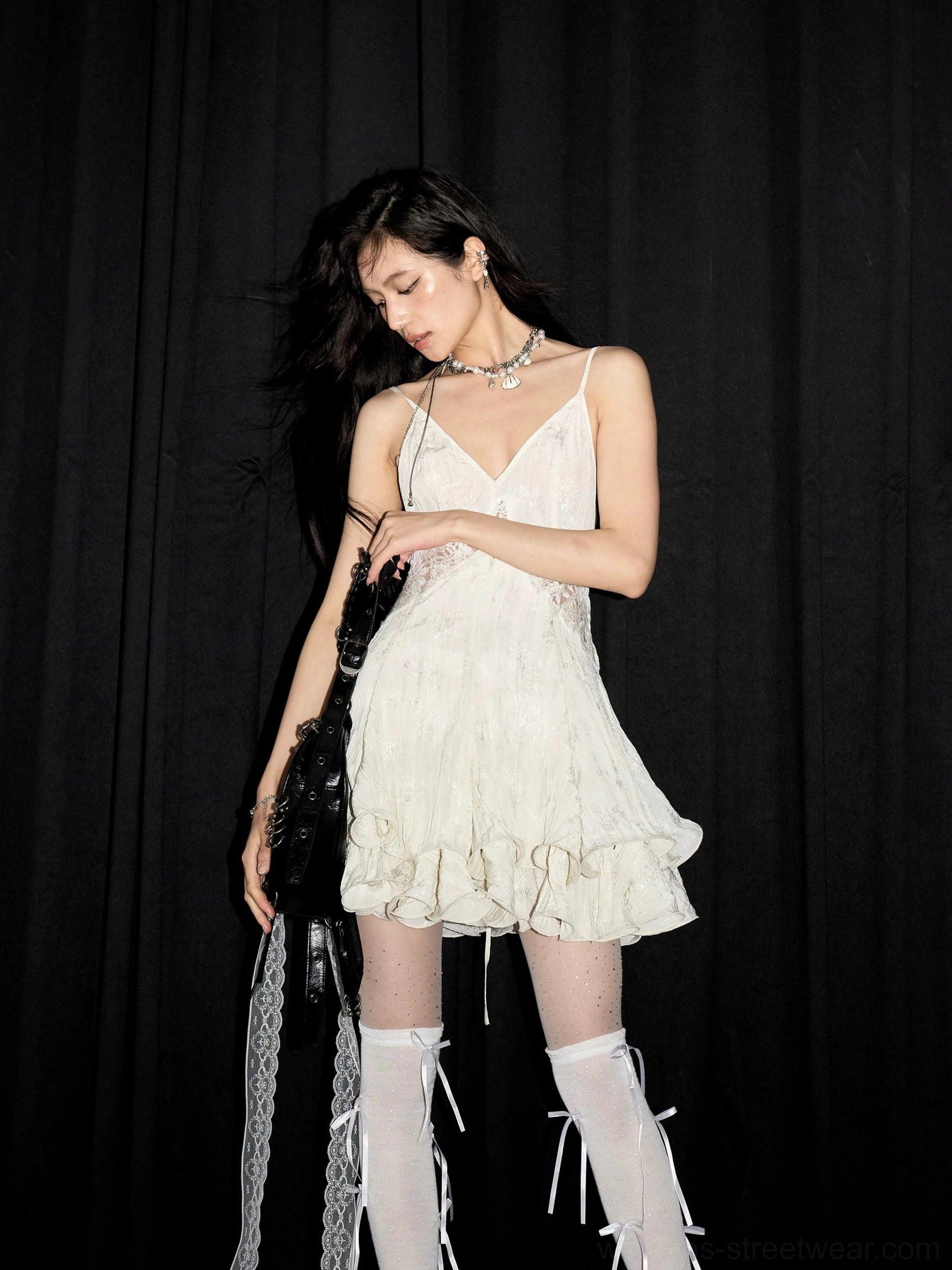 Side front view of ivory open-back lace slip mini dress with spaghetti straps and feminine ruffle skirt