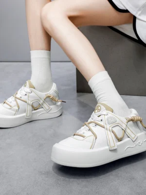 Female model wearing ivory buckle strap platform sneakers with white crew socks, showing the elevated thick platform sole from a low angle