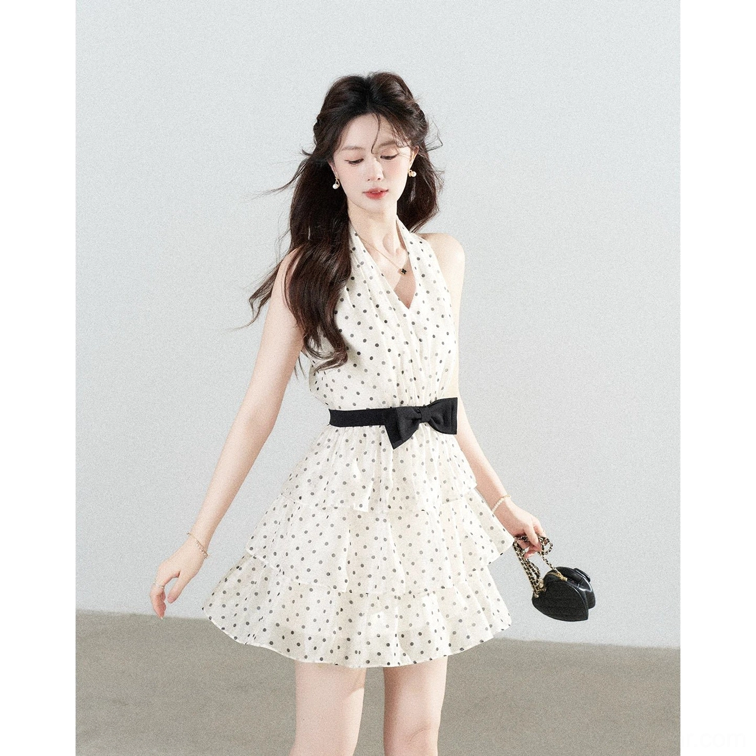Ivory polka dot bow halter tiered mini dress three-quarter side view with black bow waistband