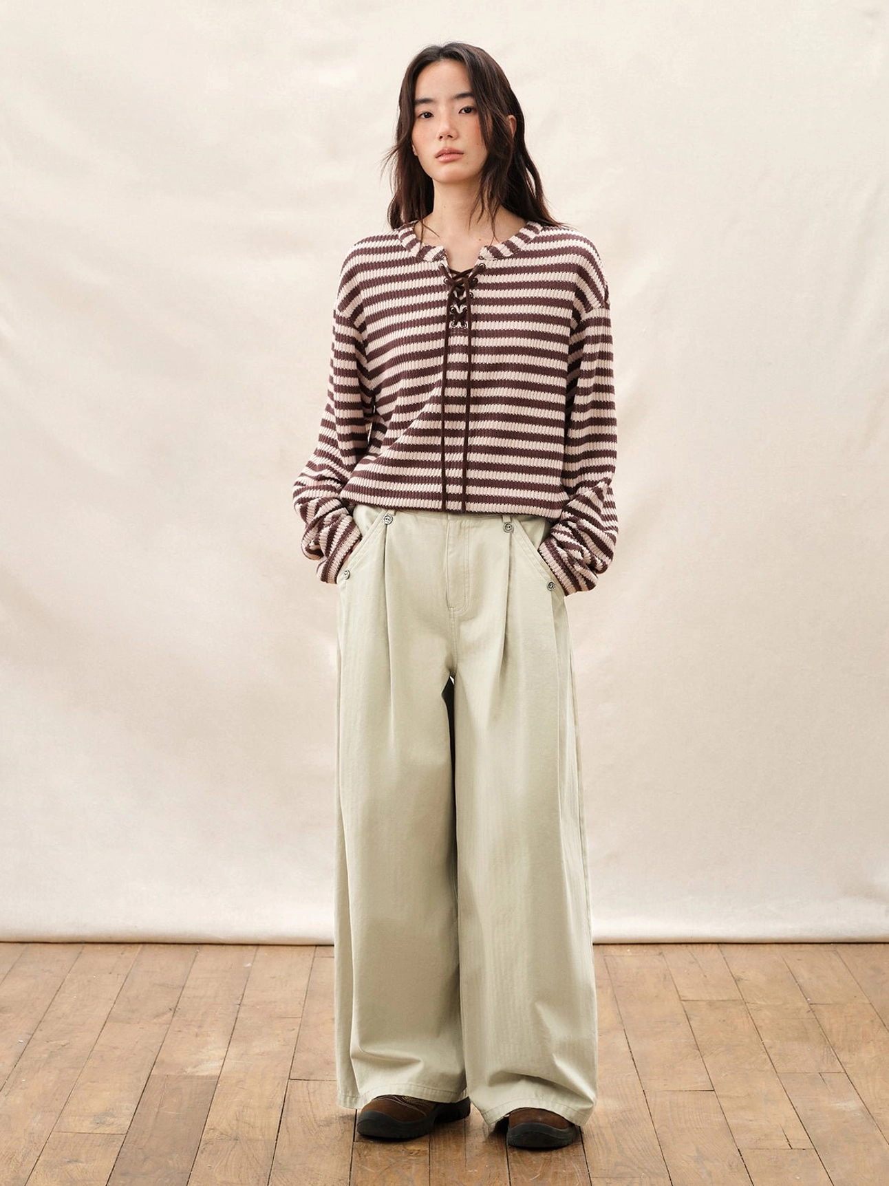 Ivory relaxed fit wide leg pleated pants styled with a striped lace up top in Korean streetwear fashion