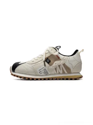 Ivory retro runner sneakers with black toe accents, layered panels, exposed stitching, and brown gum waffle sole shown in side profile
