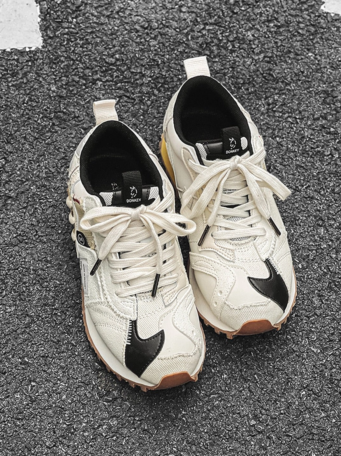 Ivory retro runner sneakers product detail showing black toe accents, cream technical panels, lace-up front, and gum sole