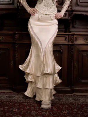 Ivory satin ruffled mermaid skirt close-up showing high waist V-shaped front inset and layered fishtail hem
