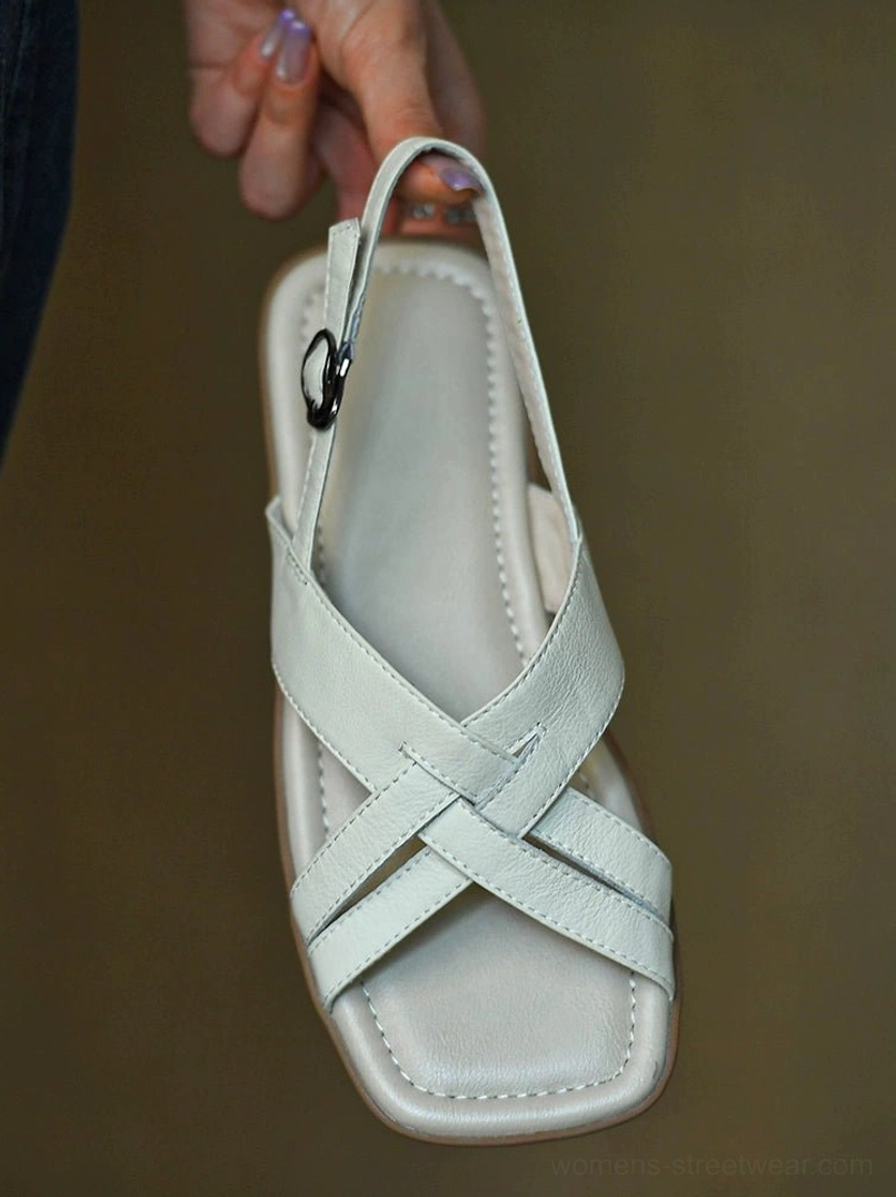 Front overhead product detail of ivory leather slingback sandals with padded footbed, square toe, overlapping straps, and metal buckle