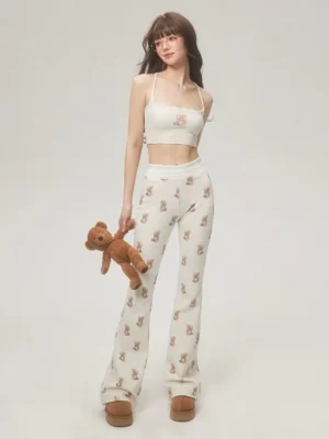 Full body Y2K outfit featuring ivory teddy bear print flare pants, matching cropped camisole, plush bear and platform boots