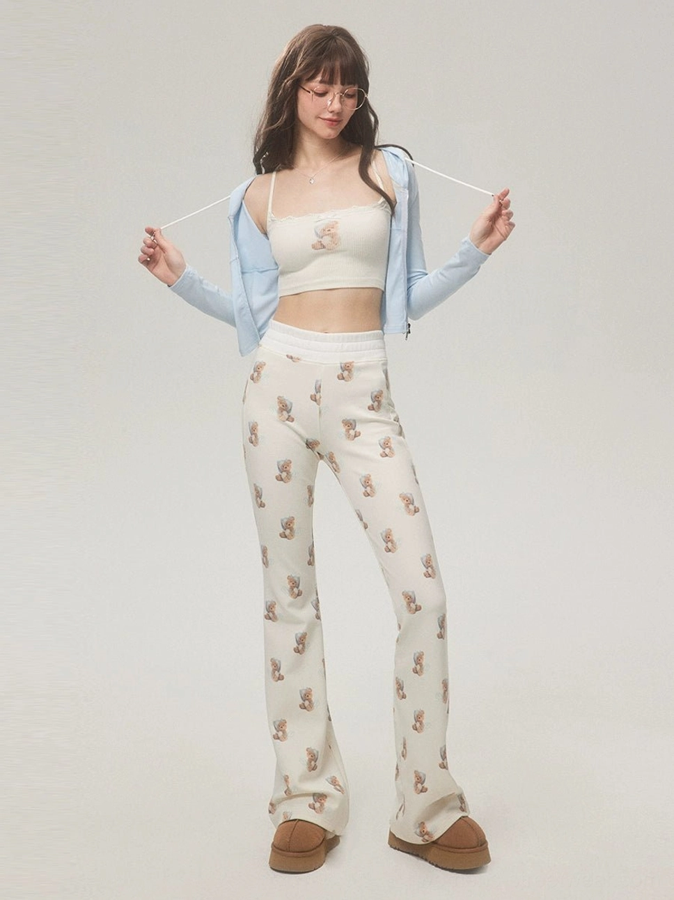 Korean-inspired teddy bear print high-waist flare pants styled with a matching crop top, blue cropped cardigan and platform boots