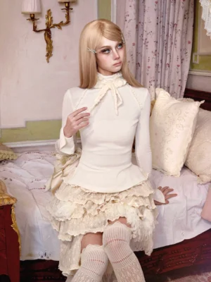 Ivory tie-neck peplum knit base layer top styled with a layered lace ruffle skirt in a romantic Korean streetwear outfit