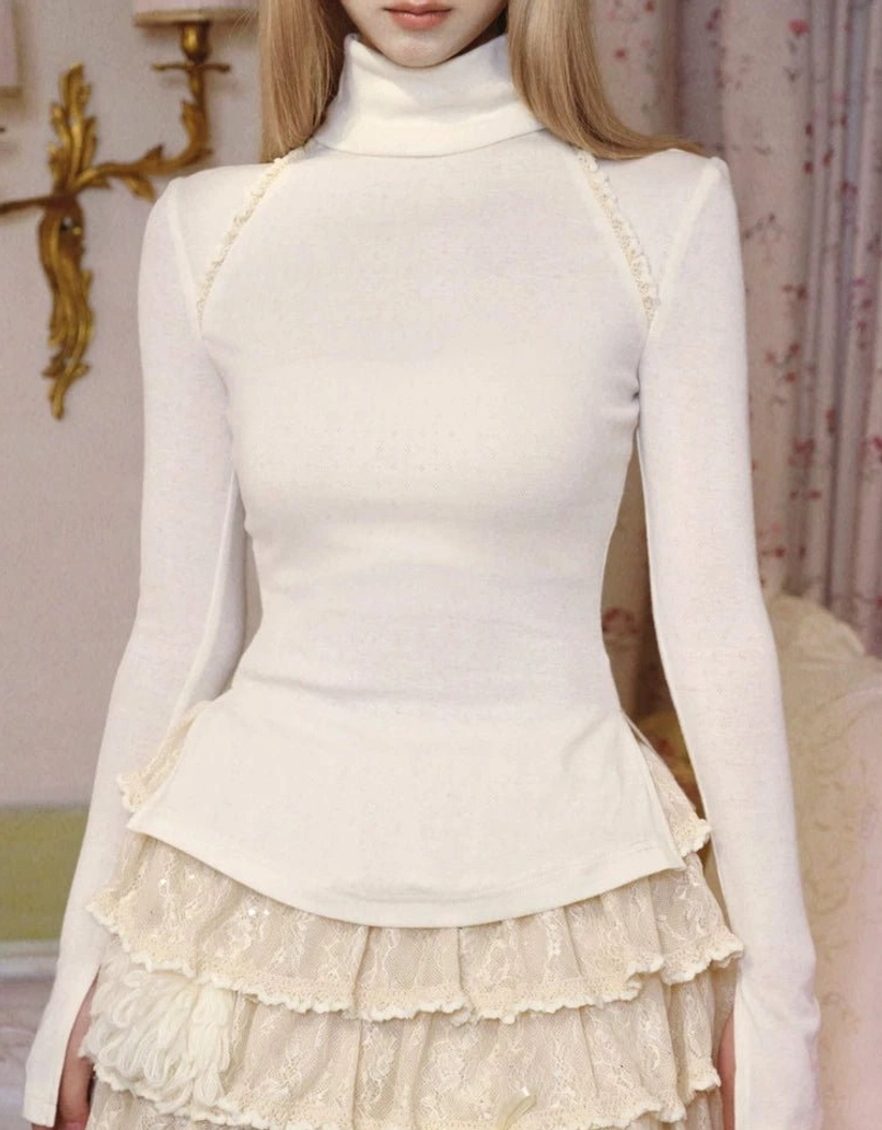 Close-up of ivory stand collar knit top showing the self-tie bow neckline fitted torso and flared peplum hem