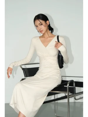 Close-up of ivory white twist front midi dress featuring a smooth matte knit finish, twisted V-neckline, and slim long sleeves