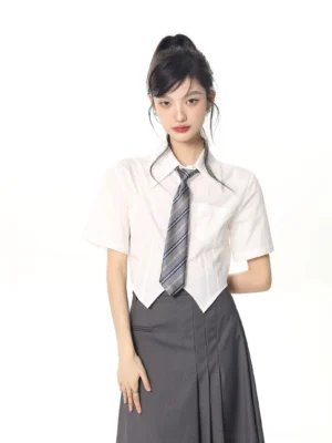 JK school uniform cropped white short-sleeve shirt with striped tie and grey pleated midi skirt full front view on model
