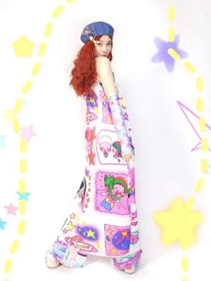 Side three-quarter view of a kawaii cartoon print maxi slip dress with spaghetti straps, floor-length loose silhouette, pastel graphics, and optional matching sleeves