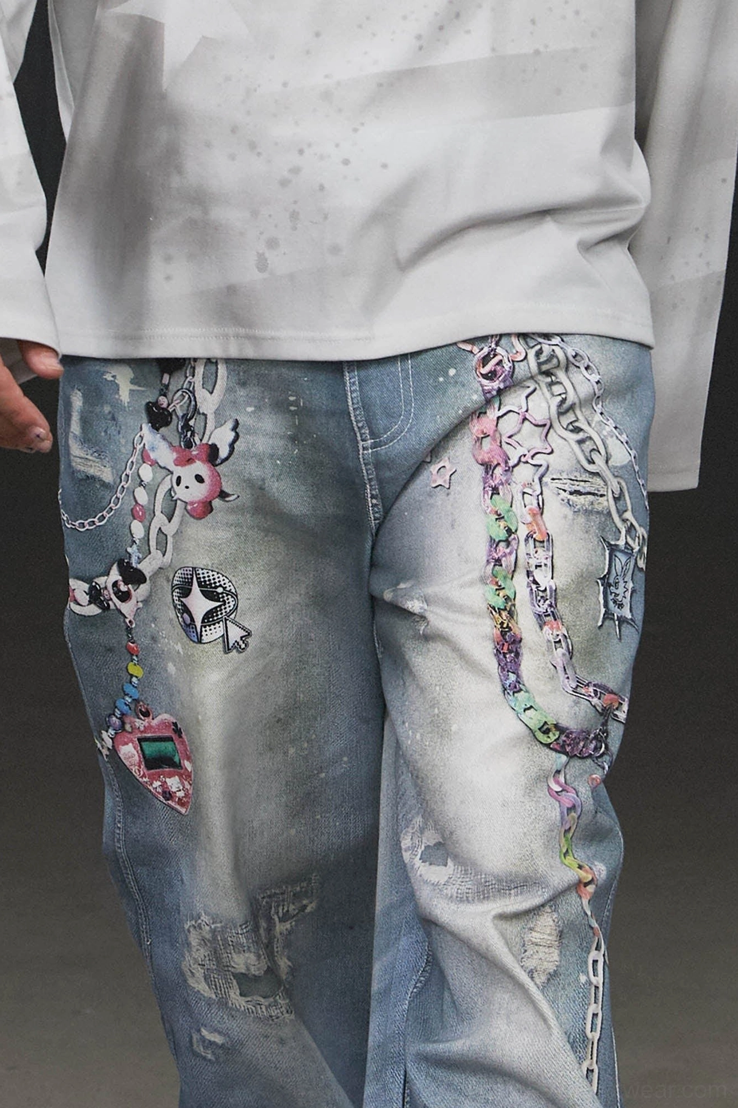 Close front view of Kawaii chain wide-leg jeans waist and upper legs with cartoon graphics star motifs distressed patches and faded denim