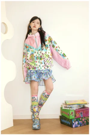 Front full-body view of a woman wearing a kawaii pink gingham patchwork windbreaker with cartoon prints and a loose oversized streetwear fit