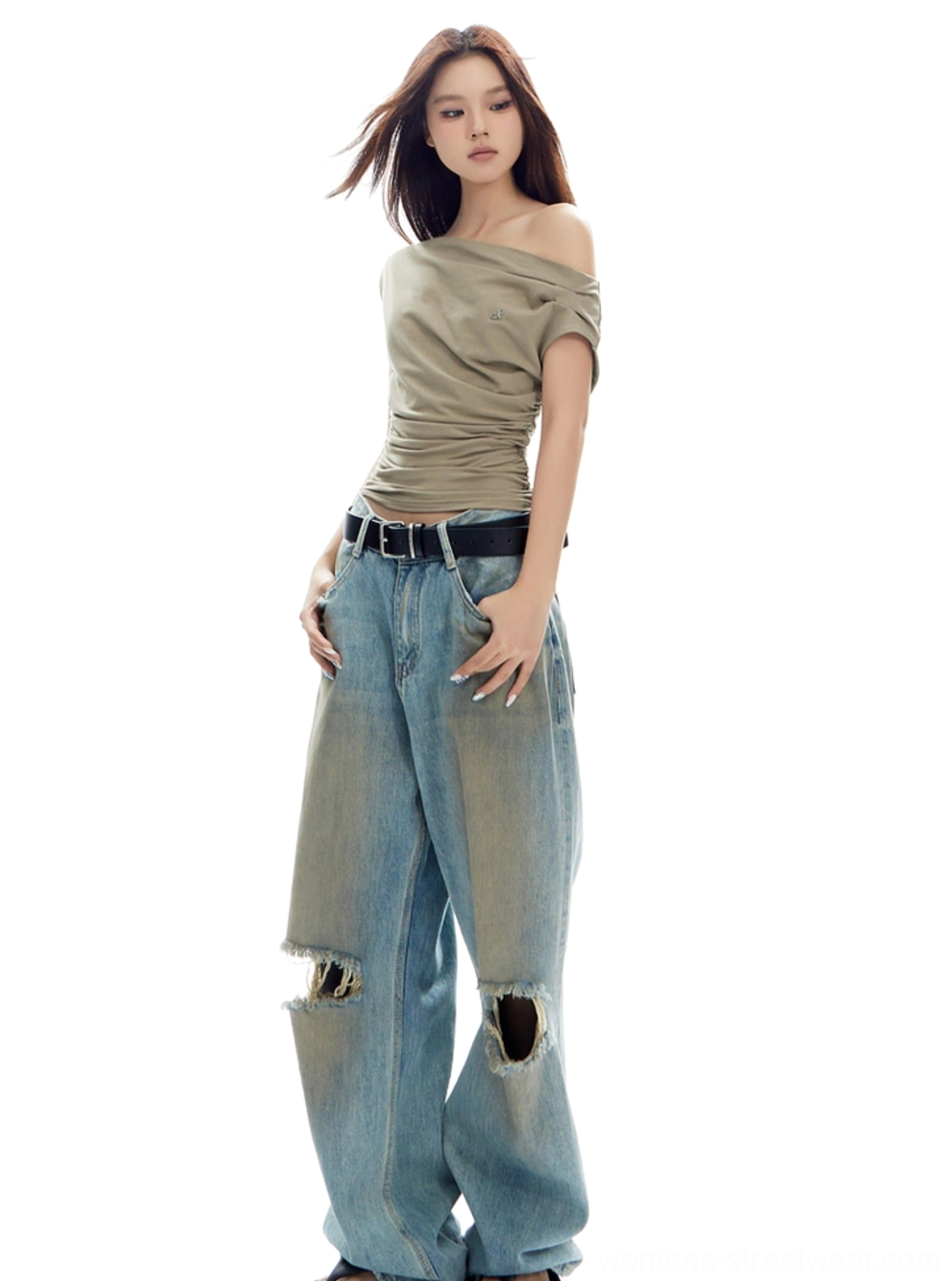 Full-body front view of khaki asymmetrical ruched top with one bare shoulder, wide-leg denim, and black belt