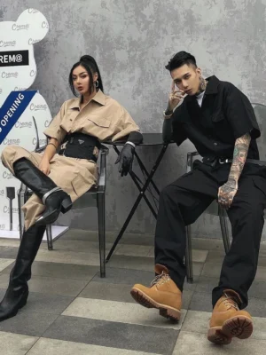 Khaki belted utility cargo jumpsuit styled with pointed toe boots in a casual cafe streetwear setting