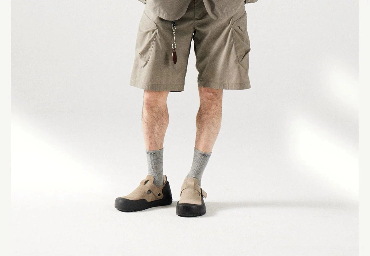 Khaki breathable cargo shorts styled with outdoor sandals and crew socks showing loose straight legs and waist accessory