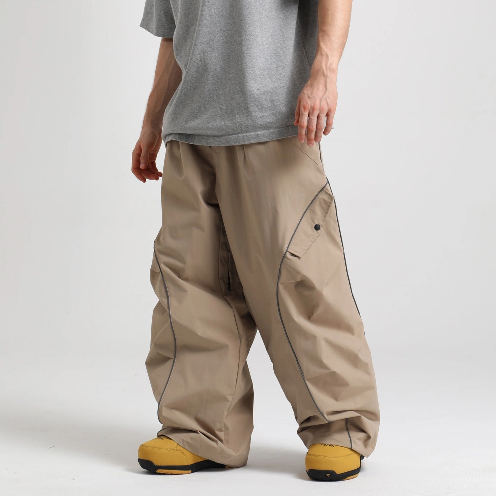 Khaki brown reflective piped baggy snowboard pants with wide-leg streetwear fit and side cargo pocket