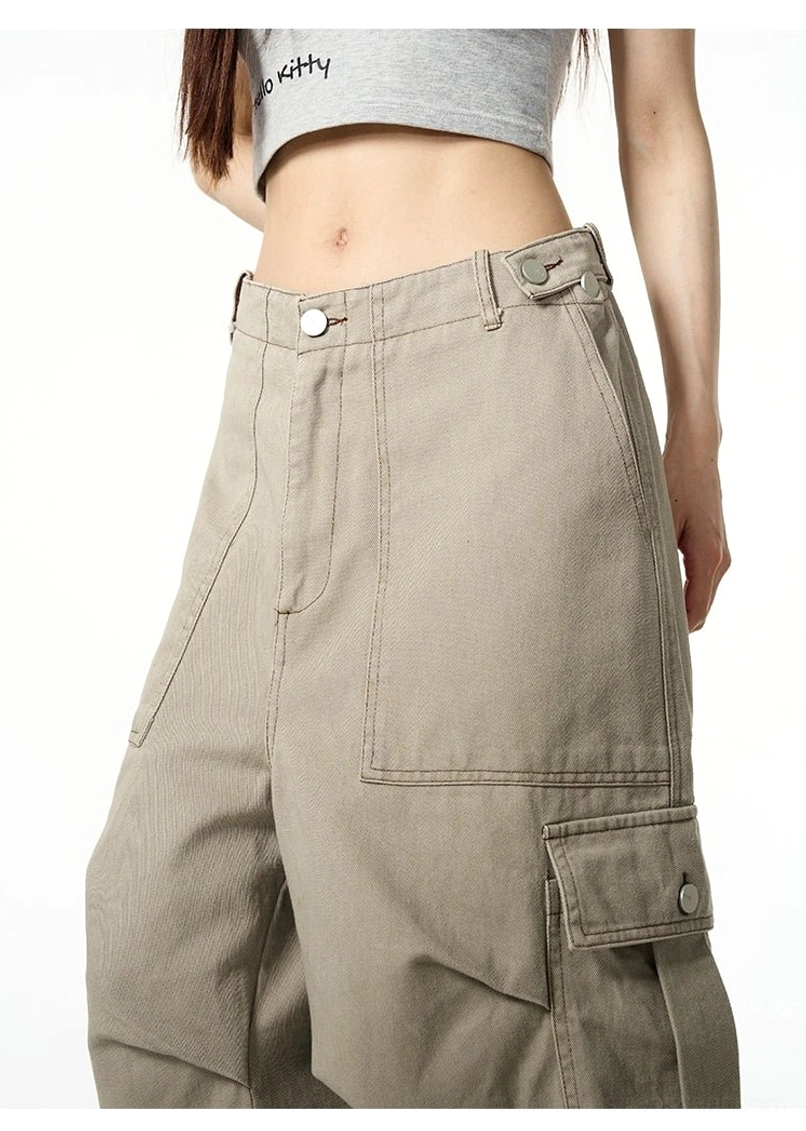 Close-up of khaki cargo pants showing button zip fly waist buckle flap cargo pockets and textured cotton fabric