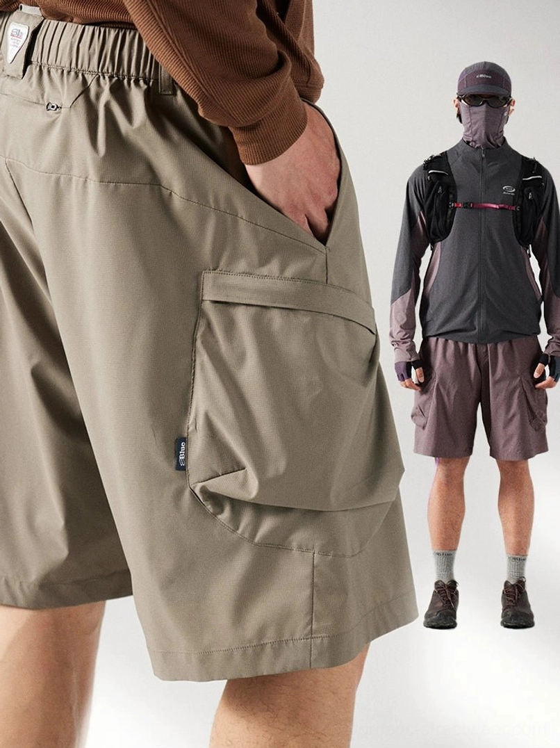 Close-up rear side view of khaki cargo shorts showing elastic waistband, 3d cargo pocket, matte fabric, and woven detail