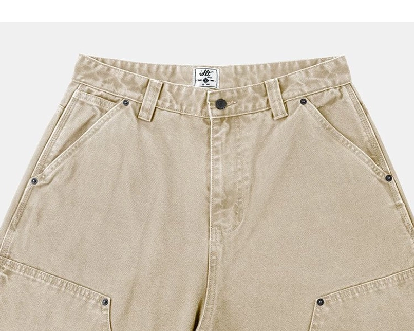 Khaki carpenter denim pants waistband close-up with button fly, belt loops, riveted pockets, and reinforced panels