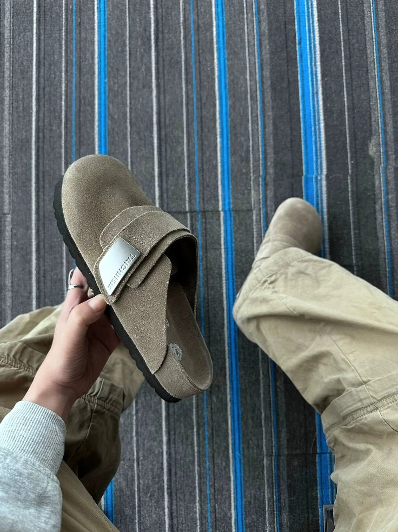 Khaki closed-toe suede mule sandals styled with cargo pants for a casual streetwear outfit