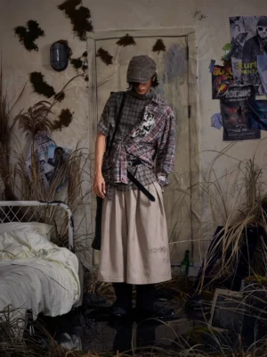 Khaki embroidered pleated cropped wide-leg streetwear trousers styled on a model in a retro bedroom