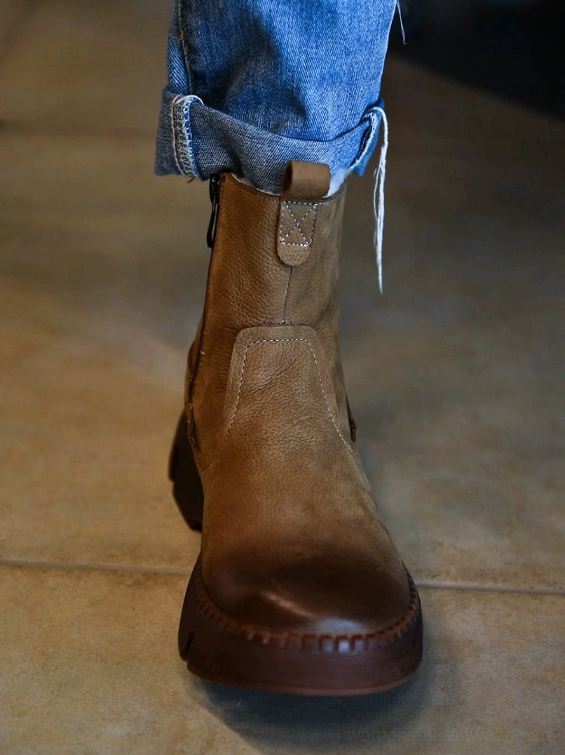 On-foot view of khaki fur-lined winter boots styled with rolled blue denim jeans and a chunky streetwear lug sole