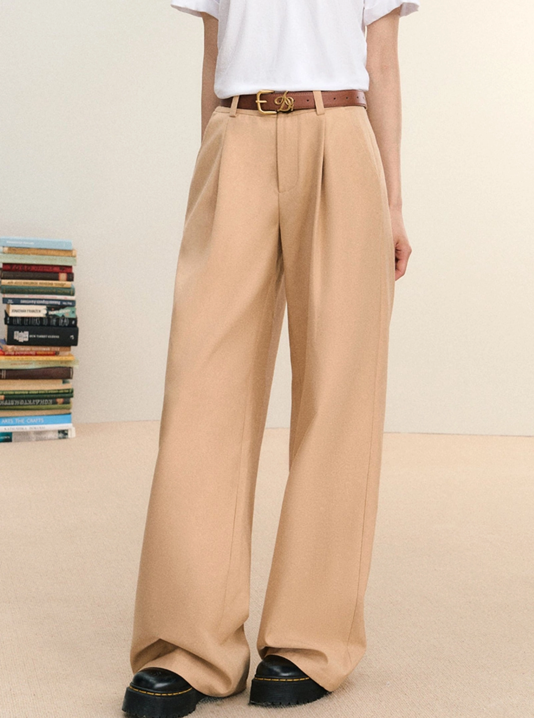 Khaki high-waist pleated wide-leg streetwear trousers shown in a full-body front view with a white T-shirt and brown leather belt