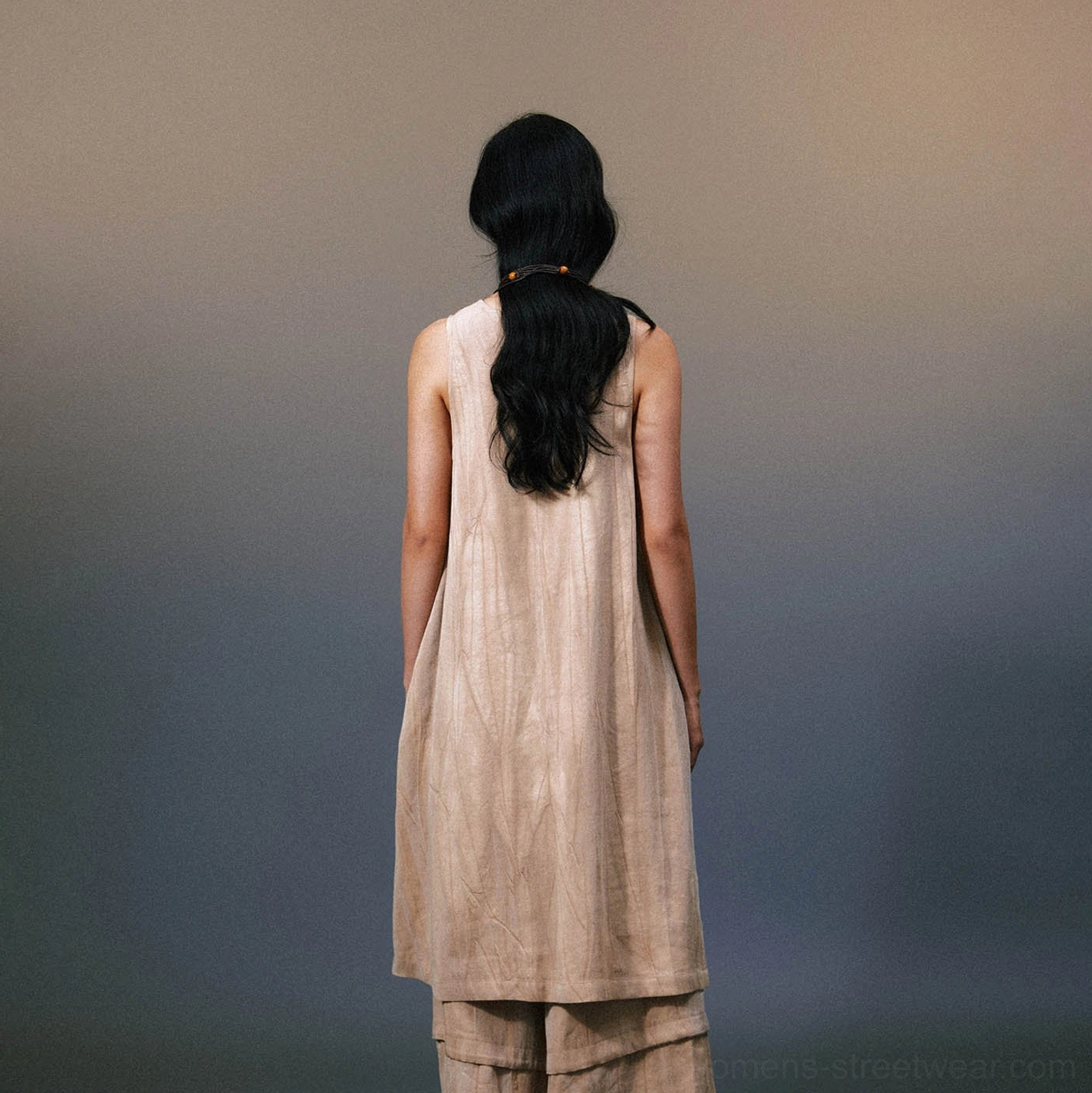 Back view of relaxed khaki linen maxi dress showing layered uneven hem and long flowing silhouette