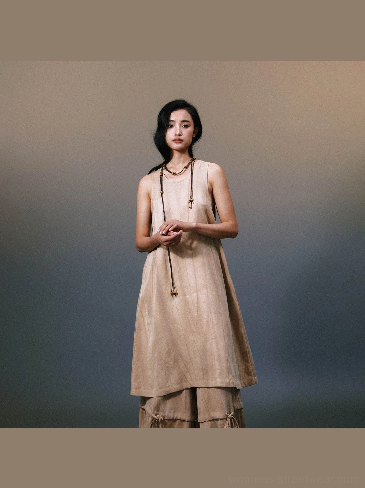 Front full-body view of khaki layered linen maxi dress with sleeveless A-line silhouette and flowing asymmetric hem