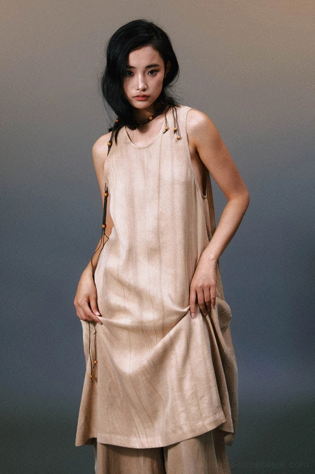Khaki layered linen maxi dress styled with wide-leg underlayer pants in an avant-garde streetwear outfit