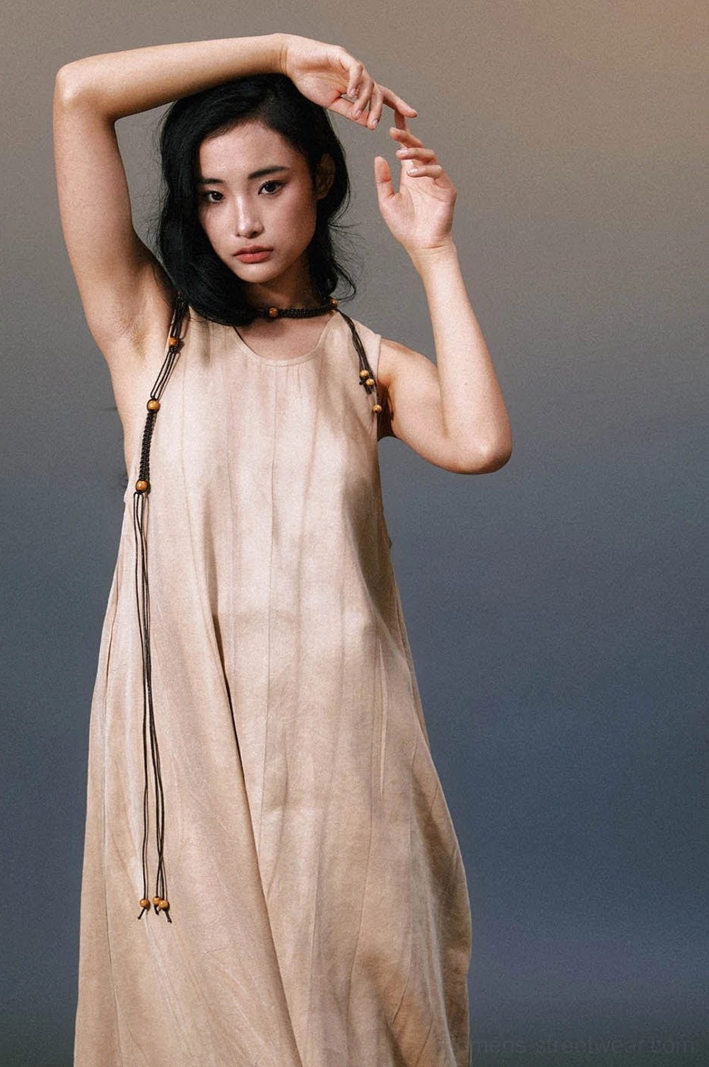 Three-quarter front view of khaki sleeveless linen maxi dress with wooden beaded adjustable neck cord