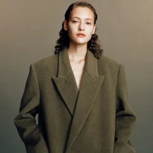 Khaki olive oversized wool peak lapel coat on a female model featuring dropped shoulders, relaxed streetwear tailoring, and a longline fit