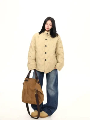 Khaki oversized wavy quilted padded jacket with relaxed fit styled with wide-leg jeans beige loafers and suede tote bag