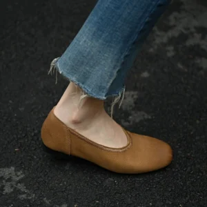 Khaki pebbled cowhide leather ballet flat with low heel and clean stitched topline worn outdoors