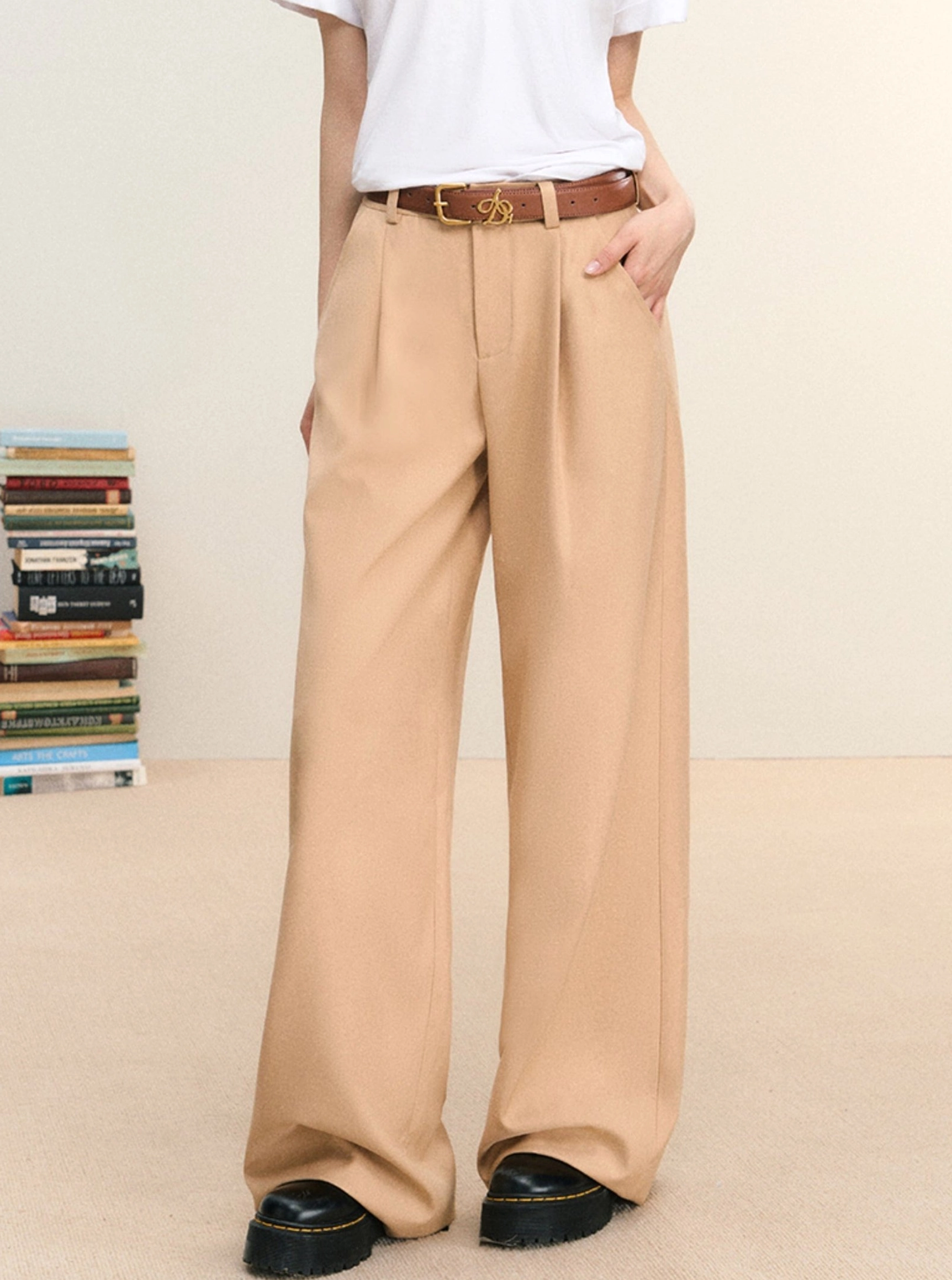 Khaki pleated wide-leg trousers styled with a white T-shirt and brown belt in a three-quarter streetwear outfit view