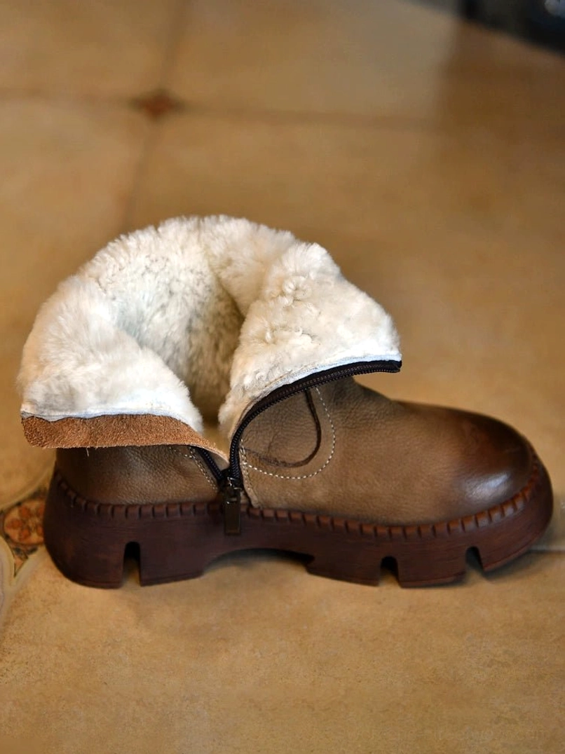 Side view of khaki shearling-lined winter boot showing plush fur interior, distressed leather upper, side zipper, and chunky lug sole