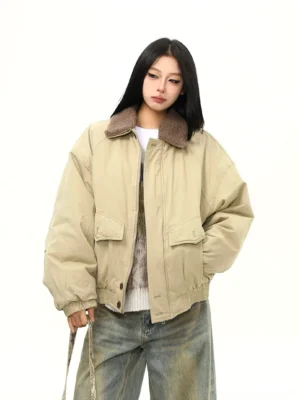 Women wearing a khaki oversized sherpa collar bomber jacket with padded body, utility flap pockets, wide leg jeans, and layered winter streetwear styling